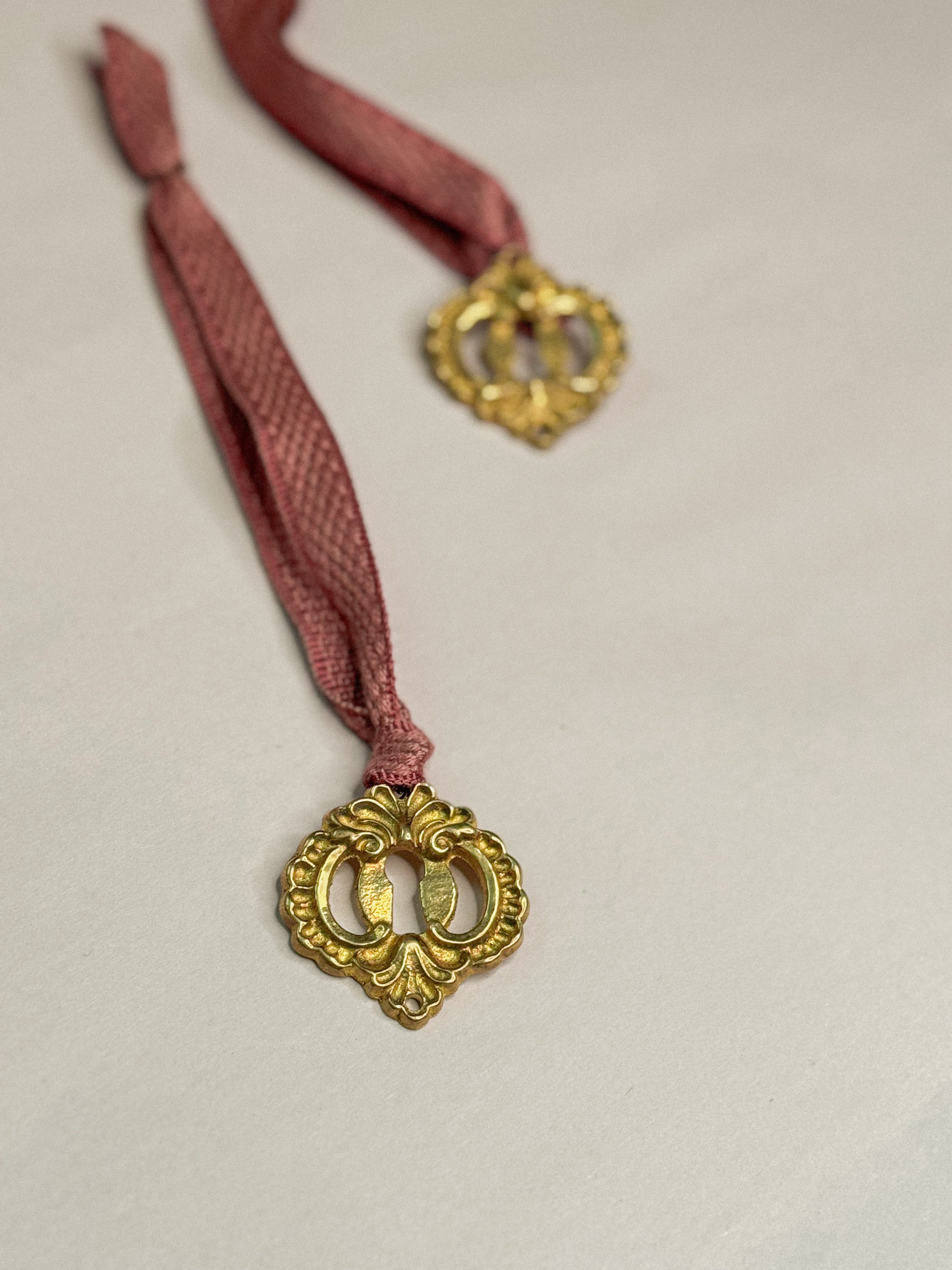 Ornament B: Escutcheon with pink ribbon