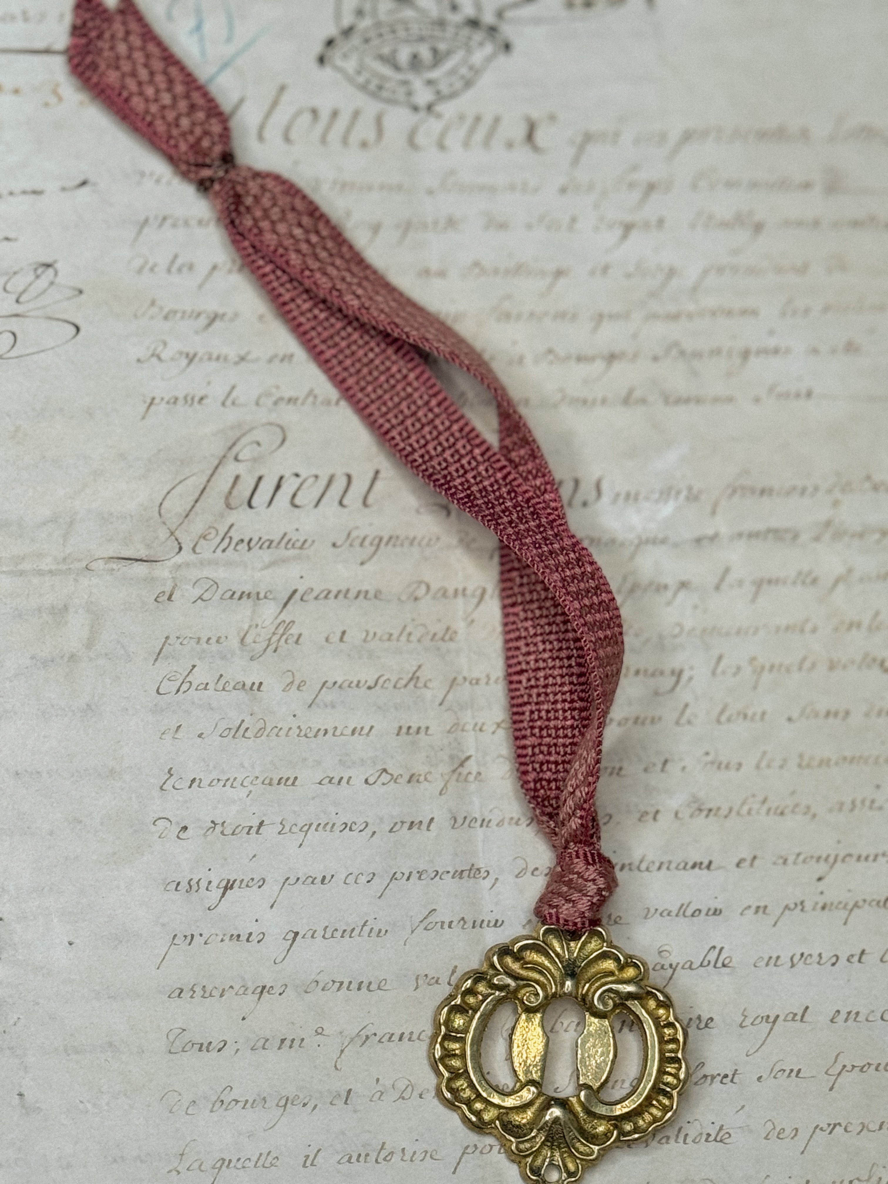 Ornament B: Escutcheon with pink ribbon